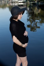 Pregnant Shannon, standing near the water.